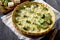 Open pie quiche Lauren with broccoli and cheese on a dark wooden table