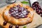 Open pie tart dough with ripe cherries