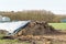 An open pile of winter feed silage for cattle in a field