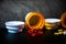 Open pill bottles on table top with red gel caps and yellow pills