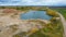 Open pit gravel mining site. Little lake or pond of unusual shape with a beautiful autumn nature and gravel piles