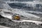 Open pit mine industry. Yellow mining truck for coal moves along dusty quarry road