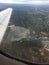 Open pit mine from plane window with wing and horizon