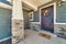 Open porch at home facade with stone wall wood siding and wreath on front door