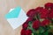 Open postal envelope with empty blue postcard and bouquet of roses