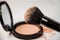 Open powder box, black make-up brush, powder hill