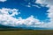 Open prairie grasslands with view of gentle foothills in distance. Summer steppe on the background of mountains and blue sky