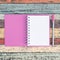 Open purple notebook and pen on vintage wood table for background and text