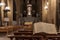 Open religious book Bible in Italian on a stand in a Catholic church in Italy against the background of benches for parishioners