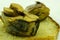 Open sandwich made of brown bread and slices of fillet of pickled Atlantic herring on a saucer among of some ingredients closeup