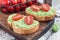 Open sandwich with mashed avocado and cherry tomatoes on toasted bread, sprinkled with black pepper, horizontal