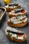 Open sandwiches with toast bread ricotta and fish sardines, on gray stone table background