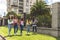 Open shot of Latina teen girl friends walking with their notebooks, backpacks, laptop and cell phone on their way to high school.