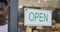 Open sign, black business man and cafe with welcome and service poster for restaurant. Coffee shop, window info and