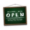 Open sign on green chalkboard in wooden frame. Information sign for front the door about working again.