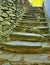 Open small steps at old building, old worn out stony steps behind house. Stony wall from raw boulders