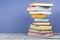 Open stacking book, hardback colorful books on wooden table and blue background. Back to school. Copy space for text. Education