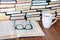 Open textbook, glasses, cup of tea and stack of old book on wooden table, education concept background, many books piles with copy