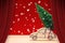 Open theater red curtains against a small pine tree on handmade cartoon toy car - Christmas holiday concept image