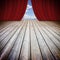 Open theater red curtains and wooden floor against a cloudy sky