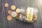 Open tilted glass jar with scattered euro coins with the inscription FUTURE on a black wooden table