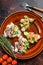 Open toast sandwich with salmon and herring, cream cheese and salad. dark background. Top view