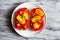 Open tomato sandwich on white plate on natural marble background. Top view, horizontal orientation