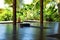 Open tropical yoga studio place with view outside to the beautiful garden with palm trees and ocean.