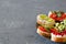 Open vegetarian sandwiches with vegetables, fruits and cream cheese on a gray background. Healthy breakfast concept.