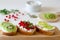 Open vegetarian sandwiches with vegetables, fruits and cream cheese on a wooden board on a white background. Kiwi and
