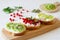 Open vegetarian sandwiches with vegetables, fruits and cream cheese on a wooden board on a white background. Kiwi and