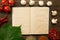 Open vintage book with berries, tomatoes, Chile peppers, spices and grape leaf on wooden background. Healthy vegetarian food.