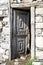 Open wood door with ornaments on cowshed in old stone house