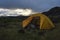 Open yellow camping tent in an open moss field during sunset. Shot on adventure in Icelandic highlands