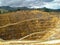 Opencast gold mine New Zealand seen behind wire fence.