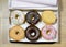 Opened box with a donut set in various flavors such as chocolate strawberry cream and candy toppings looking delicious