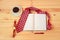 Opened diary, necktie, cup of coffee,  watch and pen on wooden table. Top view, copy space
