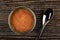 Opened metallic jar with canned pollock roe, teaspoon on dark wooden table. Top view