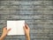 Opened notebook hand holding on wooden wall