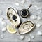 Opened oysters with black sturgeon caviar and lemon on ice on grey concrete background.