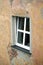 An opened plastic window on bad condition house wall covered with plaster side view vertical closeup