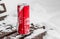 An opened red shiny bright tin can with white snow on its surface with key for cool cold soft drinks on a wooden brown
