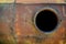 Opened rusty manhole on orange fuel tank