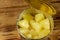 Opened tin can of pineapple pieces on wooden table