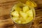 Opened tin can of pineapple pieces on wooden table