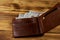 Opened wallet with american dollars on wooden table