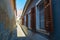 Opened wooden shutters revealing closed white window bars on a narrow street in Sibiu Hermannstadt, Romania