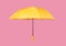 Opened yellow umbrella isolated on pink background