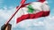 Opening boom barrier with stop sign against the Lebanonese flag. Free border crossing or lifting a ban in Lebanon