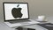 Opening laptop with Apple Inc. logo on the screen. Modern office building entrance. Modern workplace conceptual